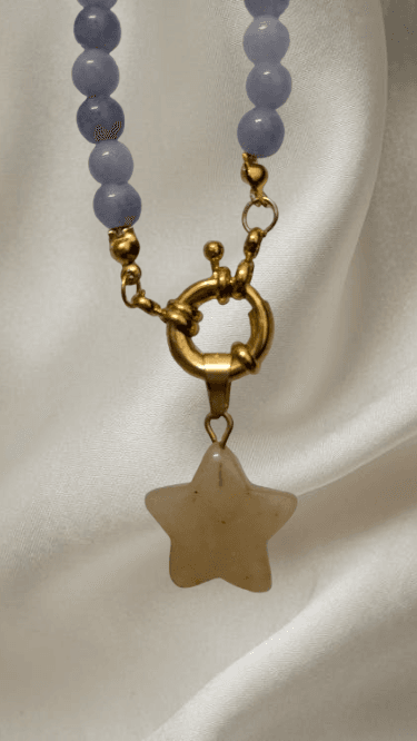 Detalle del cierre delantero de resorte dorado y el colgante de estrella de cuarzo amarillo